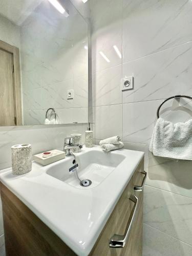 a white bathroom with a sink and a mirror at Condo in marrakech with pool in Marrakesh