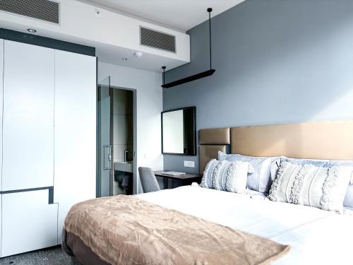 ein Schlafzimmer mit einem großen Bett und einem Schreibtisch in der Unterkunft The Capital in Sandton-Luxury aparthotel in Johannesburg