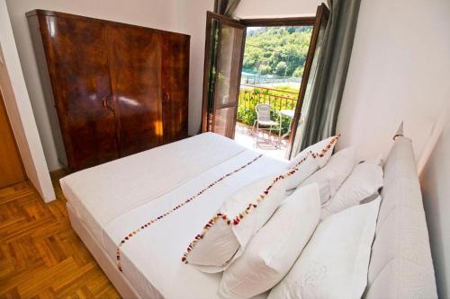 a bedroom with a bed with white pillows and a window at Family friendly house with a swimming pool Klis, Split - 21656 in Klis