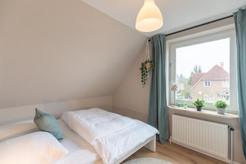 um quarto com uma cama e uma grande janela em Bräist Hus em Bredstedt