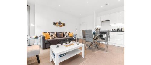 a living room with a couch and a table at Metropolitan Luxury: Chic 2BR Flat in St. Albans in St. Albans