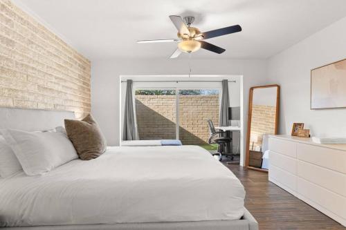 um quarto com uma cama e uma ventoinha de tecto em Charming patio home w/ community pool, WFH setups, 10 min walk to Old Town! em Scottsdale