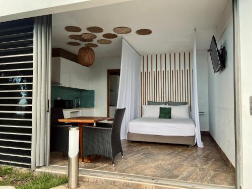 a bedroom with a bed and a desk and a table at Suite by the Pool in Faaa