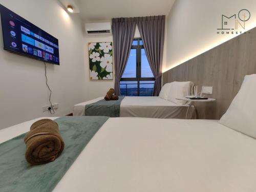 a hotel room with two beds and a flat screen tv at K Avenue Modern Style Studio (5 Mins to Airport) in Kota Kinabalu
