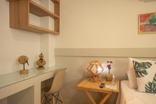 een kamer met een bed en een tafel met een bureau bij Pousada Praiana in Porto De Galinhas