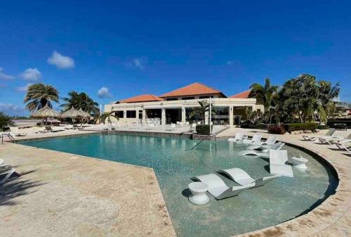 a swimming pool with lounge chairs and a resort at Condominio Gold Coast 2BR 3BTH in Palm-Eagle Beach