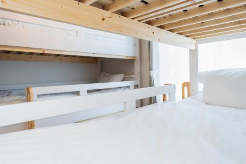 two bunk beds in a bunk bed room at 2024年3月新規オープン-最大16名-駐車場2台無料-大画面ゲーム&映画鑑賞-札幌中心部まで車で10分 in Tsukisappu