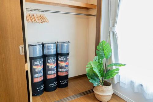 a room with four cans in a closet with a plant at 2024年3月新規オープン-最大16名-駐車場2台無料-大画面ゲーム&映画鑑賞-札幌中心部まで車で10分 in Tsukisappu