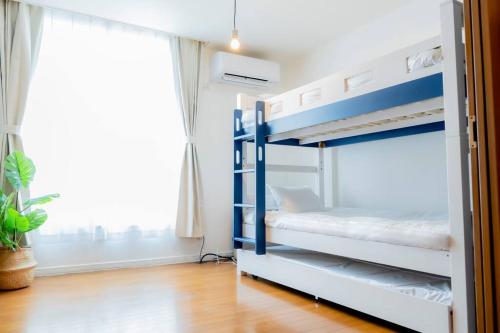a bedroom with two bunk beds and a window at 2024年3月新規オープン-最大16名-駐車場2台無料-大画面ゲーム&映画鑑賞-札幌中心部まで車で10分 in Tsukisappu