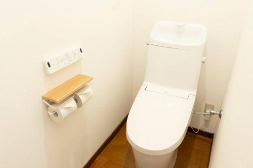 a bathroom with a white toilet in a room at 2024年3月新規オープン-最大16名-駐車場2台無料-大画面ゲーム&映画鑑賞-札幌中心部まで車で10分 in Tsukisappu