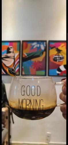 a person holding a wine glass with the words good morning at StudioRD Copacabana 250m da praia esquina com a Rua do Copacabana Palace Rodolfo Dantas in Rio de Janeiro