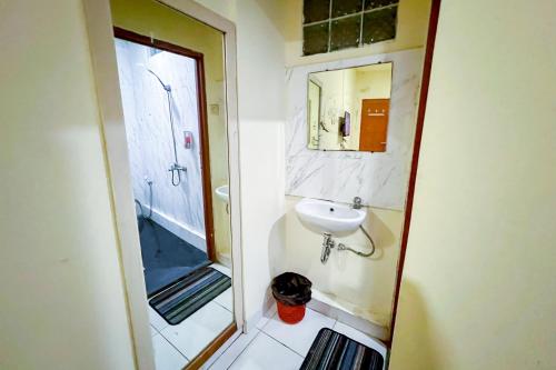 y baño pequeño con lavabo y ducha. en Wisma Berkat Mitra RedDoorz, en Yakarta