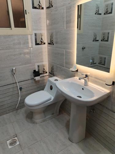a white bathroom with a toilet and a sink at شقق الياسمين in Medina