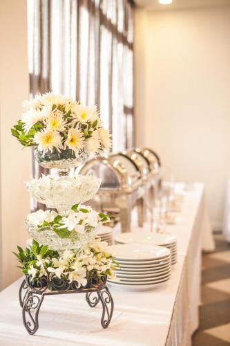 a table with plates and vases with flowers on it at Koranaree Courtyard Boutique Hotel in Nakhon Ratchasima