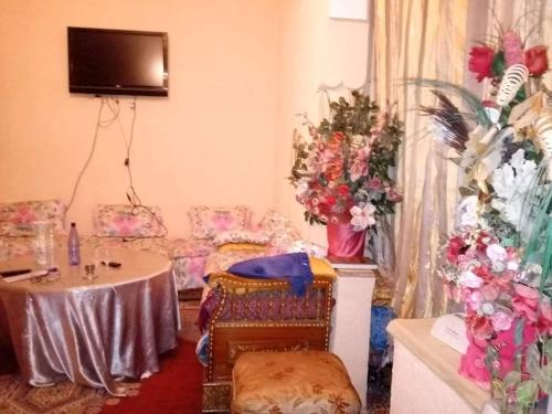 Cette chambre comprend une table, des chaises et des fleurs. dans l'établissement Maison chez lhabib, à Fès
