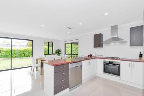 a kitchen with white cabinets and a large window at Entire home in Mount Barker in Mount Barker