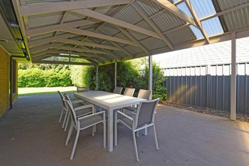 a patio with a white table and chairs under awning at Entire home in Mount Barker in Mount Barker