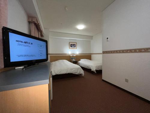una habitación de hotel con TV de pantalla plana en una barra en Hotel Alpha-One Miyoshi en Miyoshi