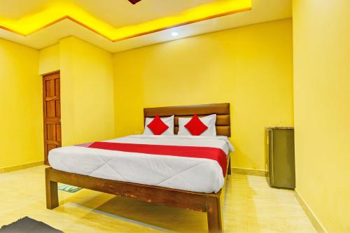 OYO Flagship Peppy Guest House في كالانغيُت: غرفة نوم بسرير في غرفة صفراء