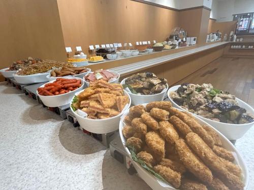 un buffet de diferentes tipos de comida en un mostrador en Hotel Alpha-One Tottori en Tottori