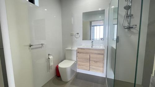 a bathroom with a toilet and a sink and a shower at Parramatta New Paint 2B2B High Floor apt next to Train and shopping in Sydney