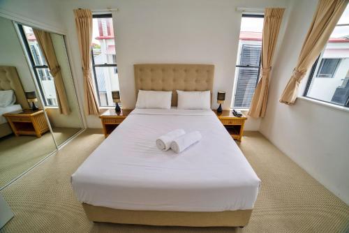 a bedroom with a large white bed with two towels on it at Coolum Beach Resort in Coolum Beach