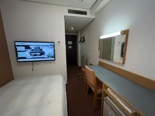 ein Krankenhauszimmer mit einem Bett und einem Spiegel in der Unterkunft Hotel Alpha-One Daini Matsue in Matsue