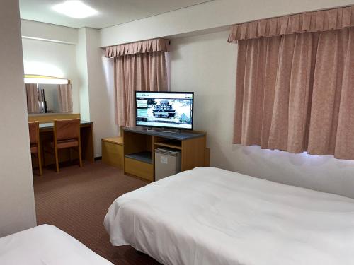 Hotel Alpha-One Daini Matsue في ماتسو: غرفة فندقية بسريرين وتلفزيون بشاشة مسطحة