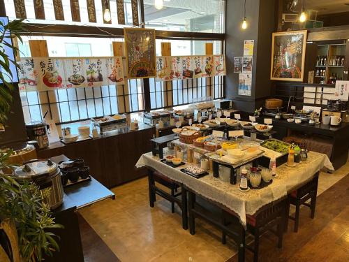 un restaurant avec une table et de la nourriture dans l'établissement Hotel Alpha-One Daini Matsue, à Matsue