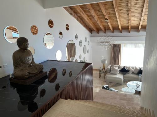 a living room with a statue of a buddha on the wall at Boskenvid Hotel - Romantic Treehouses & Skypool in Valle de Guadalupe
