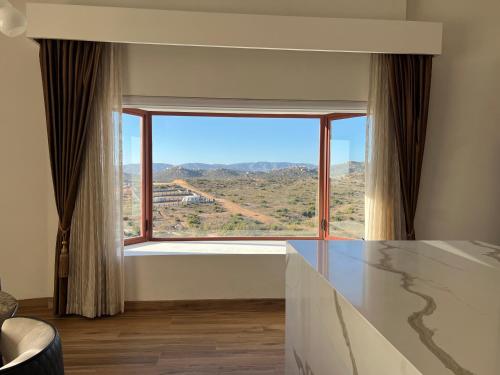 a room with a large window with a view at Boskenvid Hotel - Romantic Treehouses & Skypool in Valle de Guadalupe