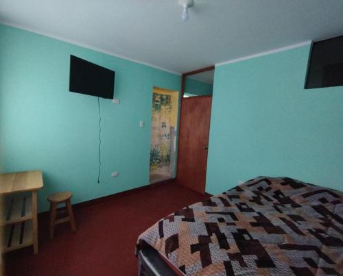 sypialnia z niebieskimi ścianami, łóżkiem i biurkiem w obiekcie Hospedaje LOS OLIVOS w mieście Ayacucho
