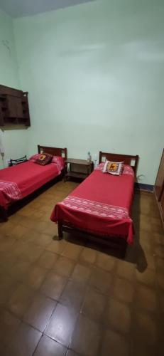 dwa łóżka w pokoju z czerwoną pościelą w obiekcie Junin 483 w mieście Victoria