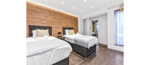 een hotelkamer met 2 bedden en een raam bij Luxury Abode: 5-Bed Haven Ideal for Big Groups! in Londen
