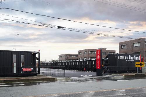 un treno è parcheggiato sul lato di una strada di HOTEL R9 The Yard 松阪 a Matsuzaka