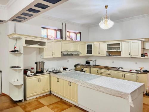 a kitchen with white cabinets and a large counter top at Гостиница Алишер in Dushanbe