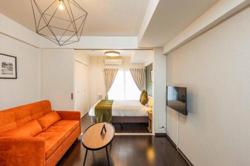 a living room with a couch and a bed at FDS Azur in Osaka