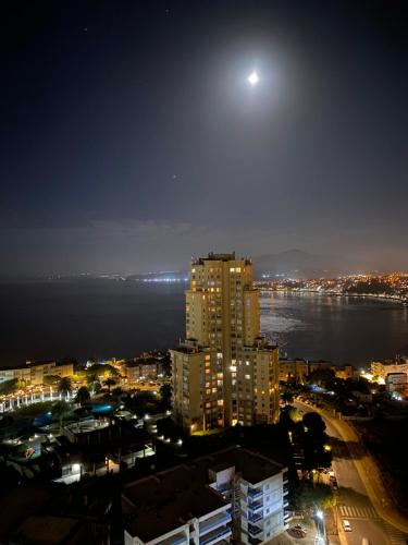 a view of a city at night with the moon at Gran Vista al Mar Moderno Depto Costa Montemar in Concón