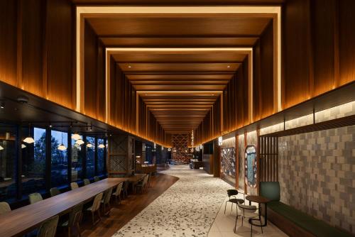 un corridoio di un edificio con sedie e tavoli di OMO5 Tokyo Gotanda by Hoshino Resorts a Tokyo