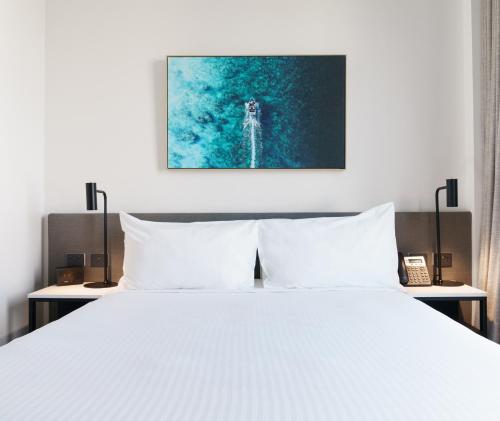 a bedroom with a white bed with two night stands at Oaks Cairns Hotel in Cairns