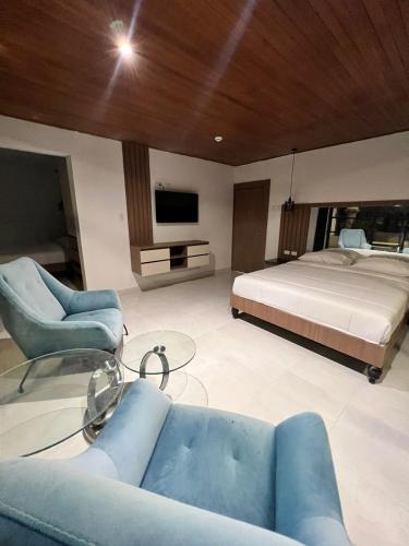 een slaapkamer met een bed, een bank en een tv bij NOVAPARK FERROVIARIA in Guayaquil