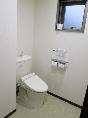 a white bathroom with a toilet and a window at Okawa Riverside Hotel in Ōkawa