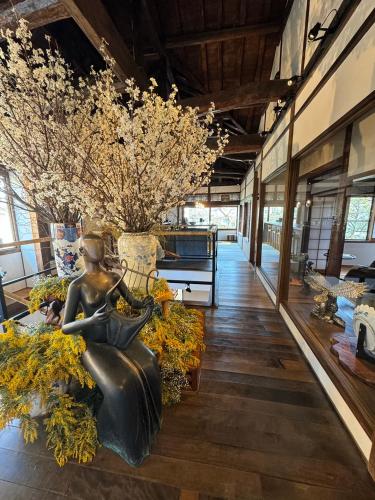 a room with a statue of a woman sitting on a couch at Kagetsu Taisyokan in Takeo