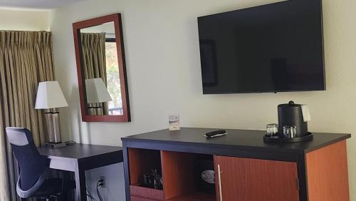 a hotel room with a flat screen tv on the wall at The Mariner Resort Cape Cod by The Red Collection in West Yarmouth