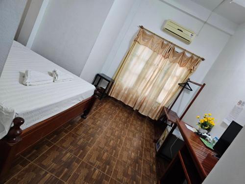 a small room with a bed and a window at Maylayguesthouse1 in Vang Vieng