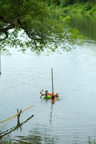 a couple of people are in the water at Tini Wood House in Hue