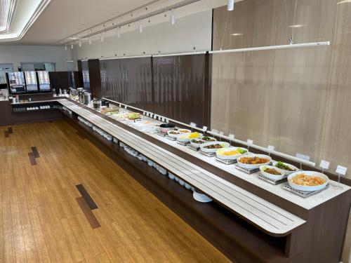 een buffet lijn met veel kommen eten erop bij Hotel Alpha-One Iwakuni in Iwakuni