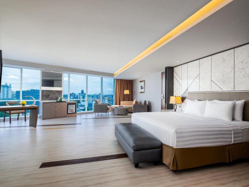 um quarto com uma cama grande e uma sala de estar em ASTON Makassar Hotel & Convention Center em Macáçar