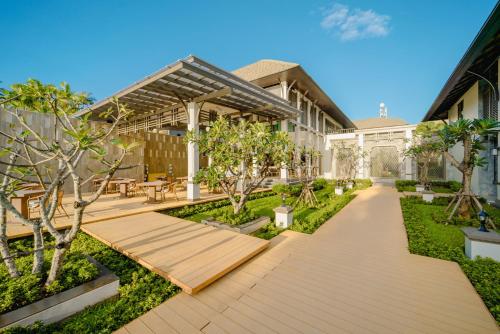 a garden with a wooden walkway in front of a building at Bhu Nga Thani Resort & Villas Railay in Railay Beach
