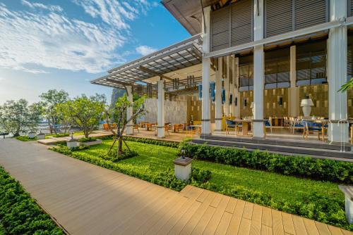 an exterior view of a building with tables and chairs at Bhu Nga Thani Resort & Villas Railay in Railay Beach